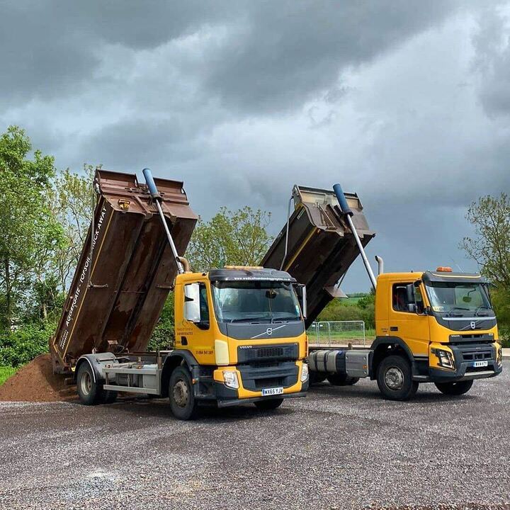 2 trucks side by side unloading sand from the back